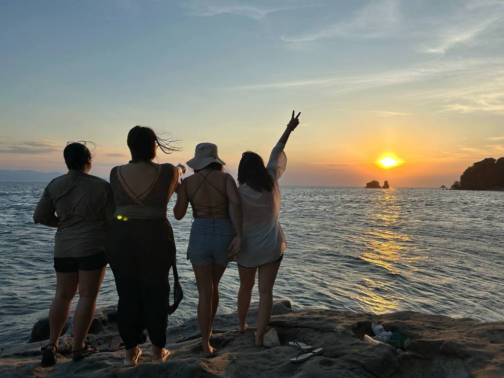 A group of  friends watching a sunset from Balatang Bato in Tingloy, Batangas.